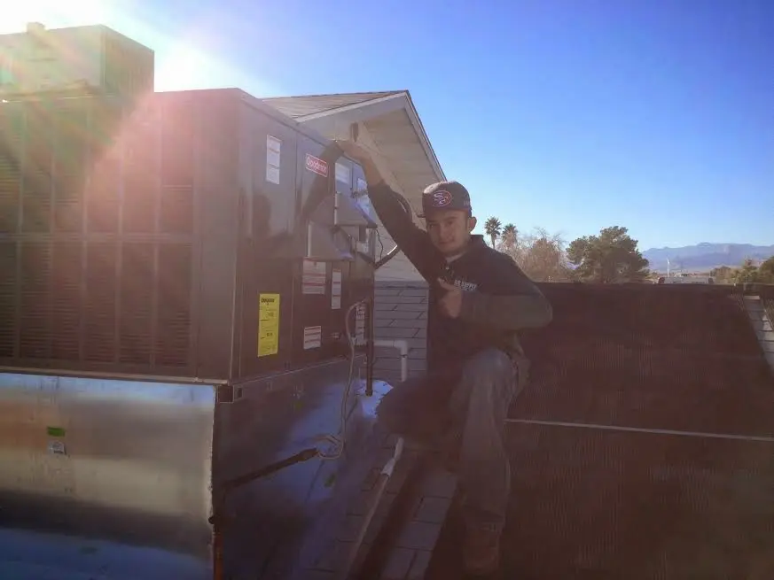 HVAC technician performing Air Duct Repair on a rooftop unit in Prescott Valley